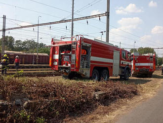 Deset hasičských jednotek likviduje požár sedmi vagónů se dřevem na nádraží v Hněvicích na…